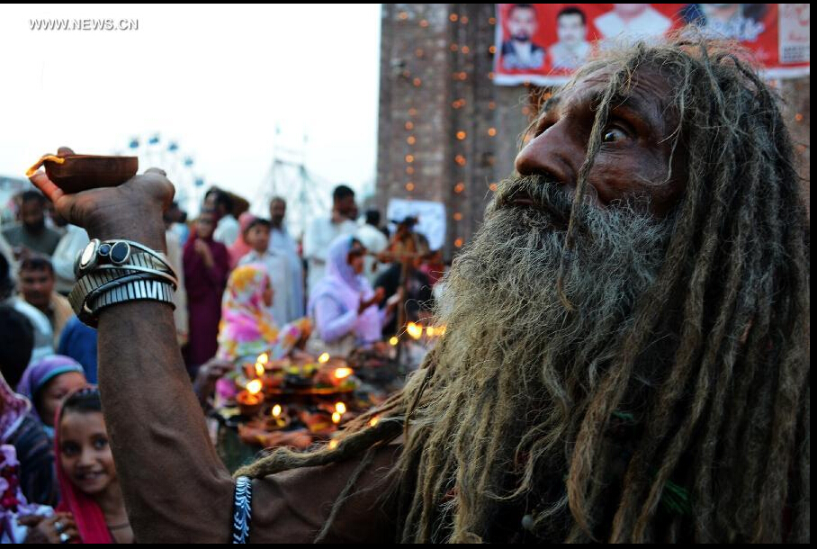 A Pakistani devotee carries an oil lamp at the shrine of Muslim Sufi saint Shah Hussain, popularly known as Madho Lal Hussain, in eastern Pakistan's Lahore on March 28, 2015. Hundreds of devotees attended the 426th annual festival celebrations known as 'Mela Chiraghan' of Madhu Lal Hussain to pay homage to the 16th century saint. (Xinhua/Jamil Ahmed) 