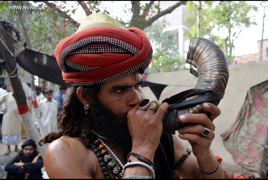 A devotee blows a horn at the shrine of Muslim Sufi saint Shah Hussain, popularly known as Madho Lal Hussain, in eastern Pakistan's Lahore on March 28, 2015. Hundreds of devotees attended the 426th annual festival celebrations known as 'Mela Chiraghan' of Madhu Lal Hussain to pay homage to the 16th century saint. (Xinhua/Jamil Ahmed)