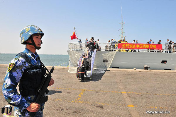 A crew member guards near a Chinese navy vessel in Aden Harbor, Yemen, March 29, 2015. China is withdrawing hundreds of citizens from Yemen with the help of Chinese warships, Foreign Ministry Spokeswoman Hua Chunying said Monday. Hua told a daily press briefing that China has already moved 122 citizens from Yemen to Djibouti. 