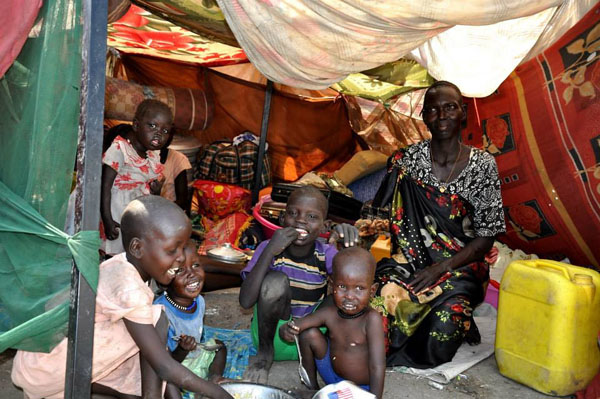 A family sitting inside a makeshift shelter at the UN compound in Malakal, Upper Nile State, South Sudan. Around 4,500 people have recently sought shelter on the premises of the United Nations Mission in South Sudan in Malakal, Upper Nile state.[Photo/OCHA] 