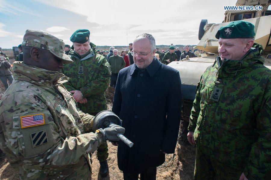 Lithuanian Defense Minister Juozas Olekas (2nd R) talks with soldiers of U.S. troops stationed in Lithuania during tank live-fire drills in Pabrade, Lithuania, on April 9, 2015. U.S. troops stationed in Lithuania held the first tank live-fire drills from April 8 to 9. [Photo/Xinhua] 