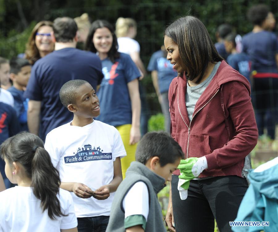 U.S. First Lady Michelle Obama(R) plants with school children in the White House Kitchen Garden on the South Lawn of the White House in Washington D.C., capital of the United States, April 15, 2015. U.S. First Lady Michelle Obama joined FoodCorps leaders and local students to plant the White House Kitchen Garden for the seventh year in a row. [Photo/Xinhua]
