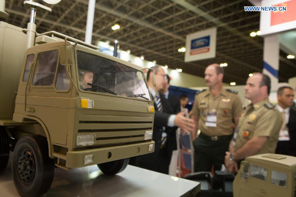 Brazilian visitors talk to the exhibitor of China Electronics Import and Export Corporation at the 2015 Latin America Aerospace and Defence (LAAD) international exhibition in Rio de Janeiro, Brazil, April 14, 2015. Chinese military products ranging from warships and missiles to computer equipment are showcasing at Latin America's most important defense and security expo in Rio de Janeiro. [Photo/Xinhua]