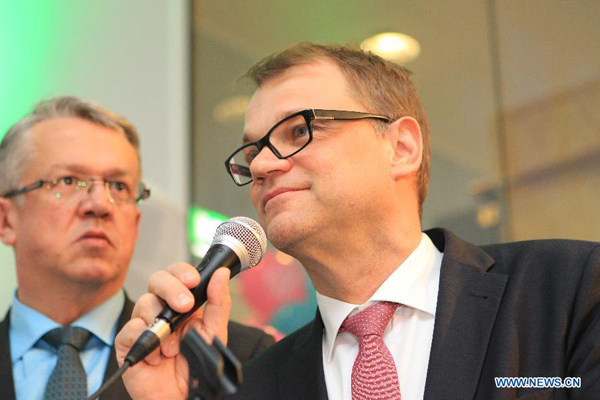 The Center Party chair Juha Sipila (R) celebrates with colleagues in Helsinki, Finland on April 19, 2015. Finland's Center Party was predicted by Finnish national broadcaster Yle to be the winner of Sunday's parliamentary election. [Photo/Xinhua]