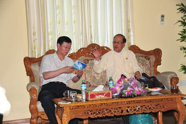 U Sein Win Aung (R), former Myanmar ambassador to China, introduces his book about China to Peng Fang (L), deputy chairman of China-Myanmar Friendship Association. [Photo: huanqiu.com]