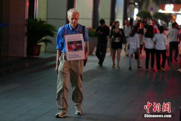 A man from Canada searches for his online girlfriend with a billboard in Shenzhen, South China's Guangdong province, April 21, 2015. 