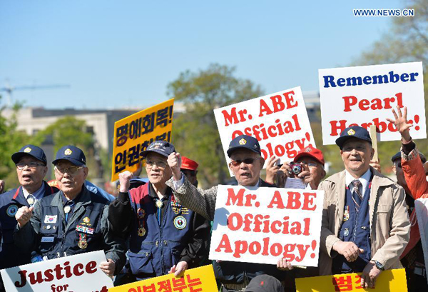 Dozens of protesters shout slogans in front of Capitol Hill as Japanese Prime Minister Shinzo Abe pays a visit to White House in Washington D.C., capital of the United States, April 28, 2015. Nearly 200 people held signs and shouted slogans in a protest against Abe's handling of history issues, demanding the Japanese leader to unequivocally apologize for his country's wartime crimes here on Tuesday. [Photo/Xinhua] 