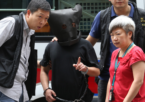 Police officers bring a suspect on Tuesday to the scene of a kidnapping last week in Ngau Chi Wan, Hong Kong. [Photo/China Daily]