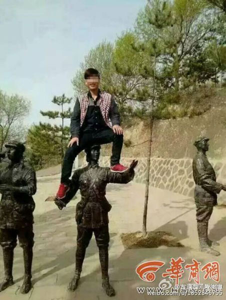 Tourist Li Wenchun climbs on top of a Red Army statue for a photo on April 23, 2015. [Photo/Weibo]