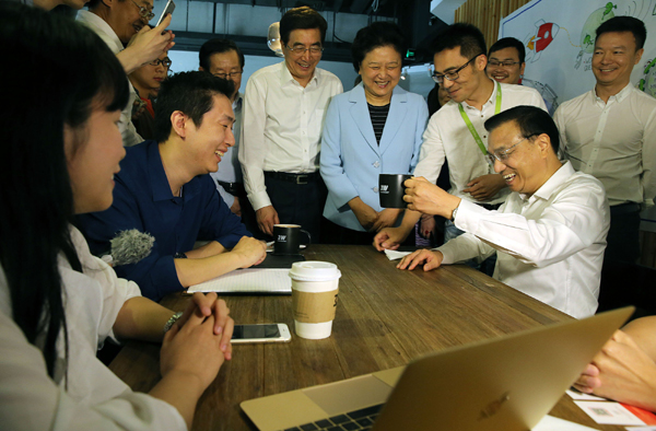 Premier Li Keqiang shares a light moment with entrepreneurs at a 3W Cafe in Zhongguancun Science Park in Beijing on Thursday. [Photo/China Daily]