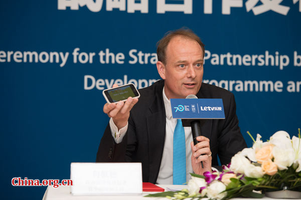 UNDP China Deputy Country Director Patrick Haverman introduces a recent mobile game app that help players understand hazardous material on May 20 in Beijing. [Photo by Chen Boyuan / China.org.cn]