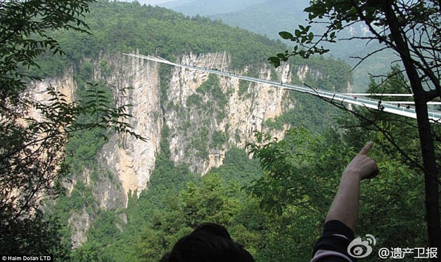 Following the world's longest cantilever bridge in Chongqing, another record-breaking glass bridge will open in Zhangjiajie, Hunan Province in July. The structure, which is 430 meters long, six meters wide and 300 meters above the valley floor, can carry 800 people. [Weibo.com]