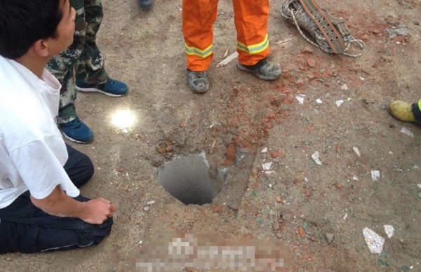 A relative of the kid keeps talking to the boy, to make sure he is awake. The photo shows the well in which the two-year-old fell into, which measures 30cm wide and 40 meters deep. [Photo / Offical Sina Weibo of Fire Department of Shaanxi Public Security Bureau]