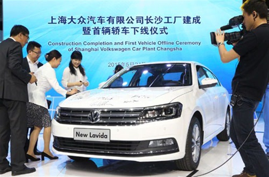 Guests sign names on a Lavida sedan to celebrate the first car that rolled off the production line at Shanghai Volkswagen’s new plant in Changsha, Hunan Province, yesterday. — Xinhua