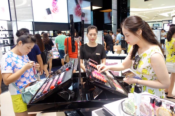 Tourists select cosmetics at Sanya Haitang Bay International Shopping Mall.[Photo by Huang Yiming / China Daily] 