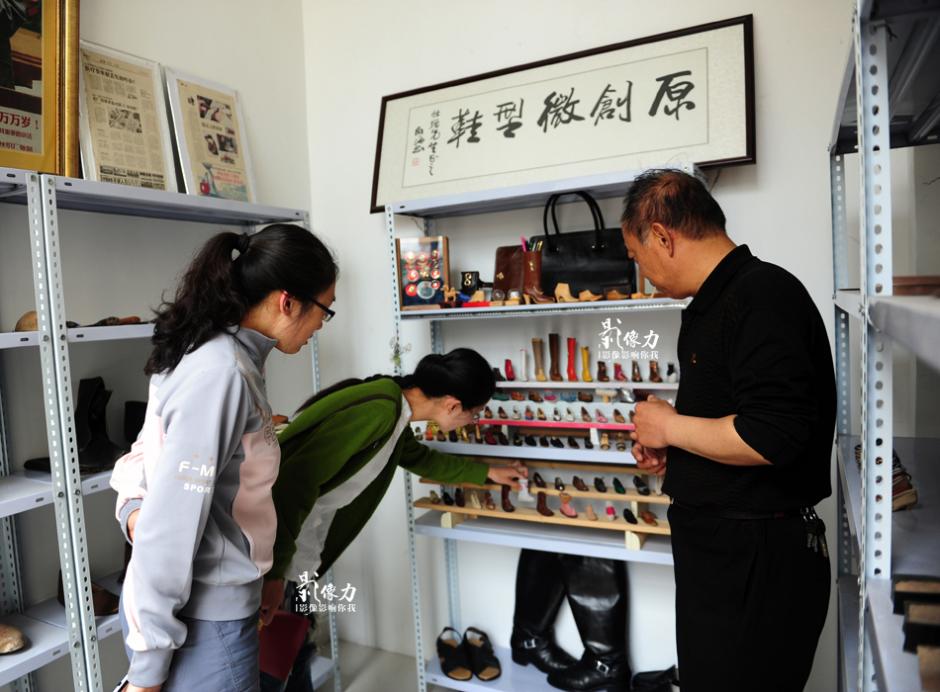 Visitors look at the miniature shoes in Peng's workshop. [Photo/Zhang Wei, iqilu.com] 