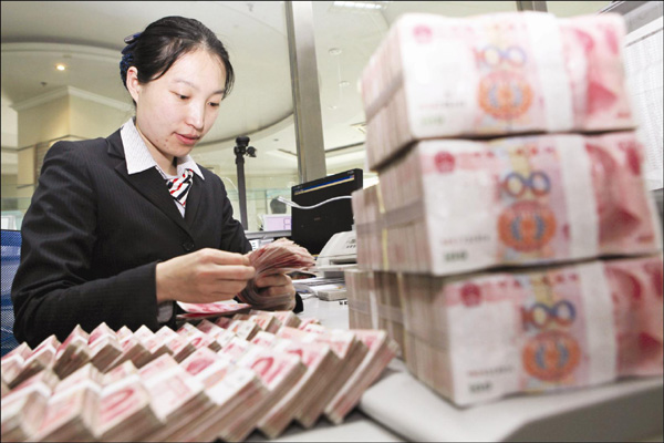 A teller counts money in a bank in Ganyu county, eastern Jiangsu province. The IMF is expected to declare soon that the currency is now fairly valued. [Photo/China Daily] 