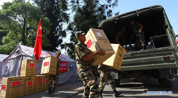 Nepal Army personnel load relief materials to a truck after a handover ceremony of China-aided medical supplies to Nepal in Kathmandu, Nepal, May 27, 2015. Chinese medical aid, including medical equipment, laboratory materials and other medical supplies, is worth 40 million Nepalese rupees (about 390,000 U.S. dollars). [Photo/Xinhua]