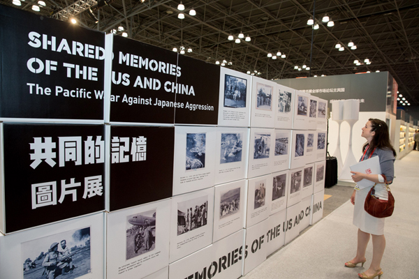 A visitor looks at photos at 'Shared Memories of the US and China' photo exhibition during the BookExpo America (BEA) 2015 in New York, the United States, on May 28, 2015. 