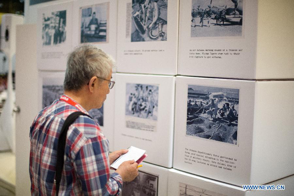 A man looks at photos at 'Shared Memories of the US and China' photo exhibition during the BookExpo America (BEA) 2015 in New York, the United States, on May 28, 2015.