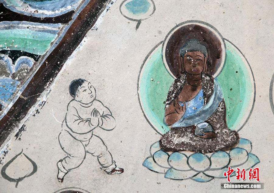 A Dunhuang fresco portrays a child worshiping the Buddha. [Photo: Chinanews.com]