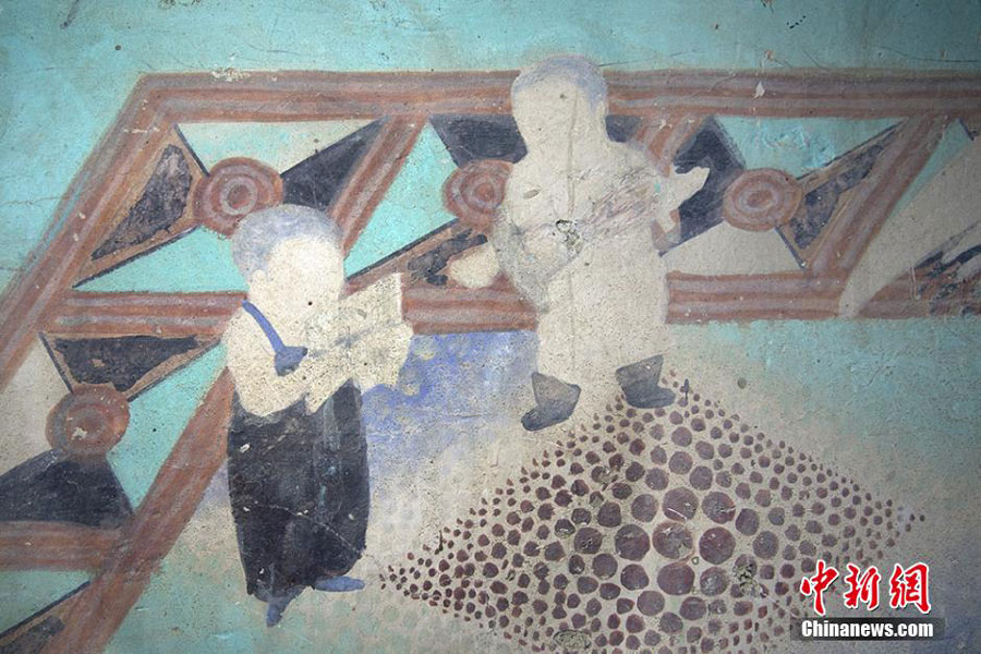 A Dunhuang fresco portrays two children playing musical instruments. [Photo: Chinanews.com] 