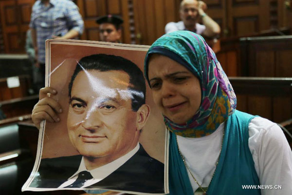 A supporter of Egypt's former President Hosni Mubarak holding his portrait reacts at a court in Cairo, Egypt, on June 4, 2015. Egypt's Court of Cassation, the country's highest legal authority, on Thursday ordered a retrial of former President Hosni Mubarak over the killing of protesters in 2011, state-run MENA news agency reported. [Photo/Xinhua]