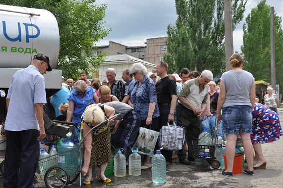 In Ukraine, residents of conflict-affected Stakhanov, Luhansk oblast, collect drinking water. [Photo: UNICEF Ukraine]