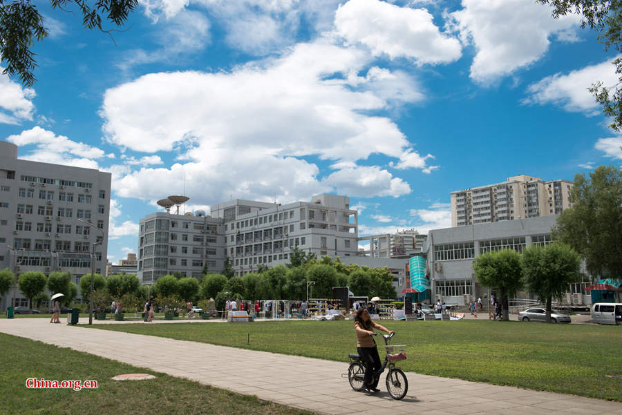 The sky above Capital Normal University in downtown Beijing is a crystal-clear blue on Thursday, June 11, 2015, after days of thunderstorms. Sunshine piercing through the white clouds brings a summery look to everything in the city below. [Photo by Chen Boyuan / China.org.cn]