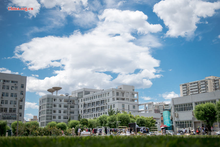 The sky above Capital Normal University in downtown Beijing is a crystal-clear blue on Thursday, June 11, 2015, after days of thunderstorms. Sunshine piercing through the white clouds brings a summery look to everything in the city below. [Photo by Chen Boyuan / China.org.cn]