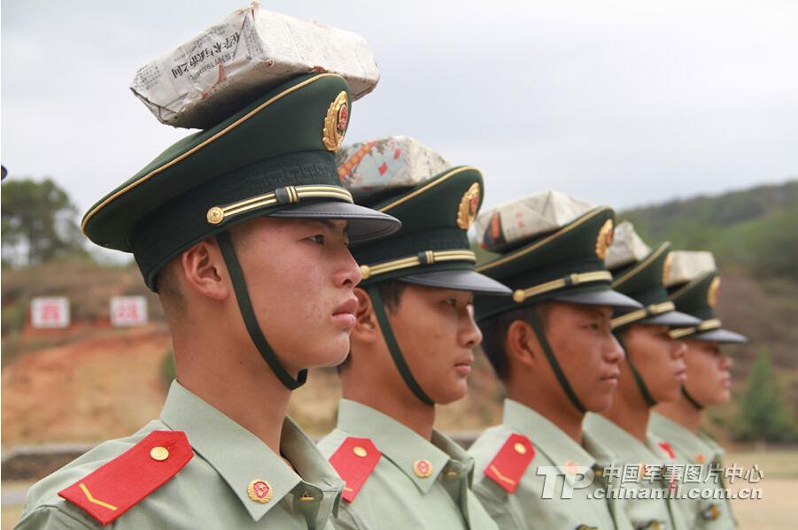 为了练就静如雕塑的身姿，头顶砖头不算啥。天空飘来五个字，那都不是事。 [中国军网 李华时 摄]