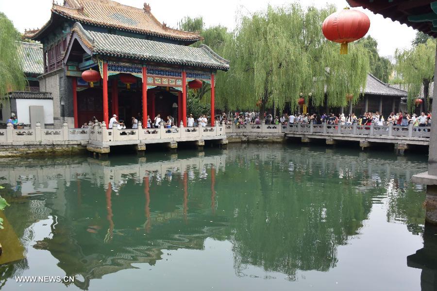 Tourists visit the Baotu Spring in Jinan, capital of east China's Shandong Province, June 22, 2015. The famous scenery spot Baotu Spring stopped spouting due to low underground water level during the Dragon Boat festival holiday. [Xinhua]