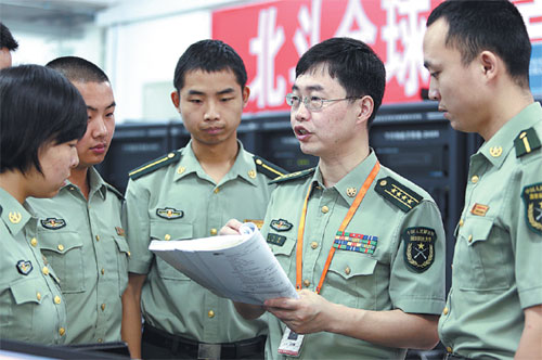 Wang Feixue (second right) discusses with team members at the Center for Satellite Navigation and Positioning Technology of the National University of Defense Technology in Changsha, Hunan province, on May 26. The center undertakes most of Beidou system's research and development. 