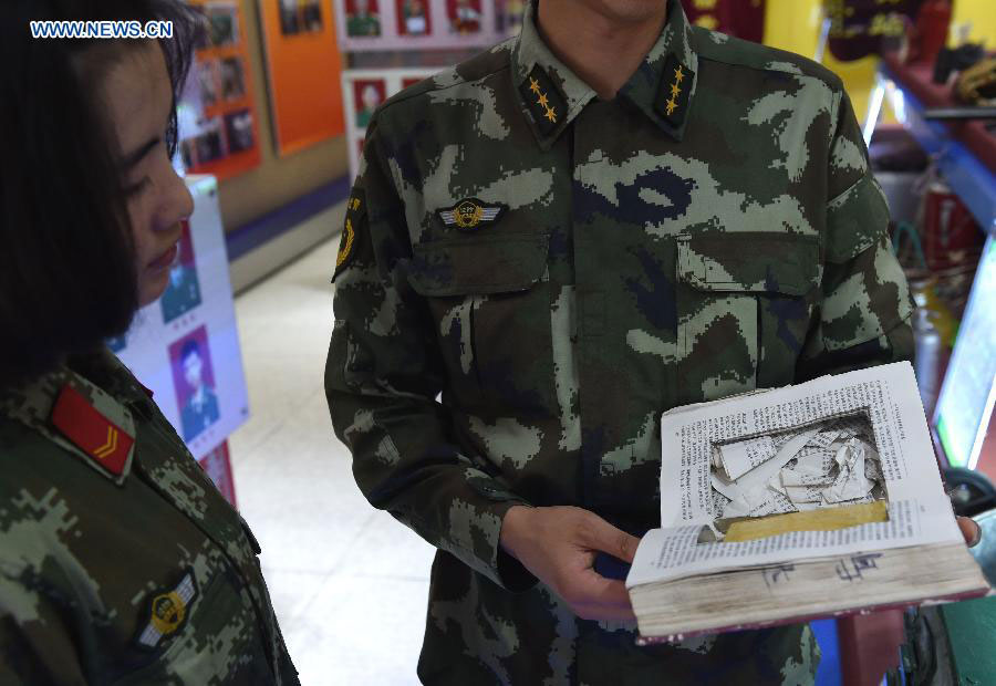 Zhang Liu (L) learns how traffickers hide drugs from a veteran at the border checkpoint of Mukang in Dehong Dai-Jingpo autonomous prefecture, Southwest China's Yunnan province, June 24, 2015. [Photo/Xinhua]