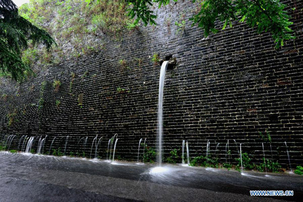 Water seeps through the city wall built during the Ming Dynasty (1368-1644) in Nanjing, capital city of east China's Jiangsu Province, June 27, 2015. [Photo/Xinhua]