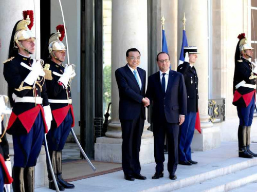 Chinese Premier Li Keqiang and French President Francois Hollande greet the media at the Elysee Palace in Paris on Tuesday. [Chinanews.com]