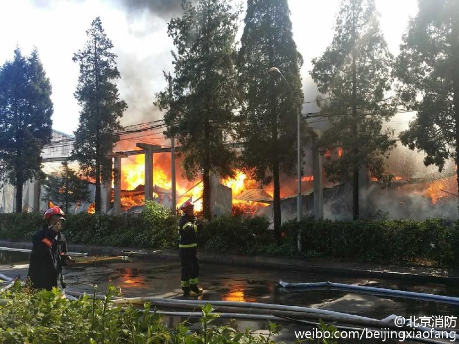 Firefighters put out the fire in a ware house of a wood factory in southern Beijing, China on June 30, 2015. [Photo: weibo.com/beijingxiaofang]