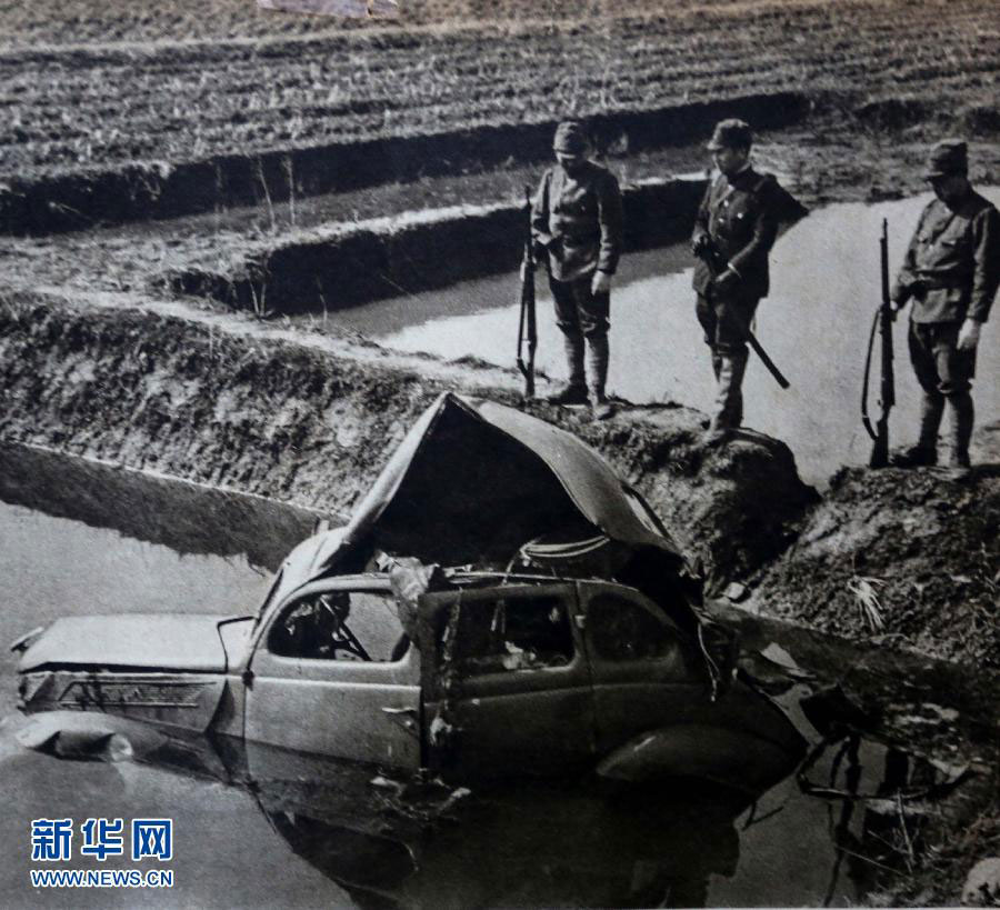 Three Japanese soldiers observe the wreckage of a car destroyed by a guerrilla-made land mine. [Photo: Xinhua]