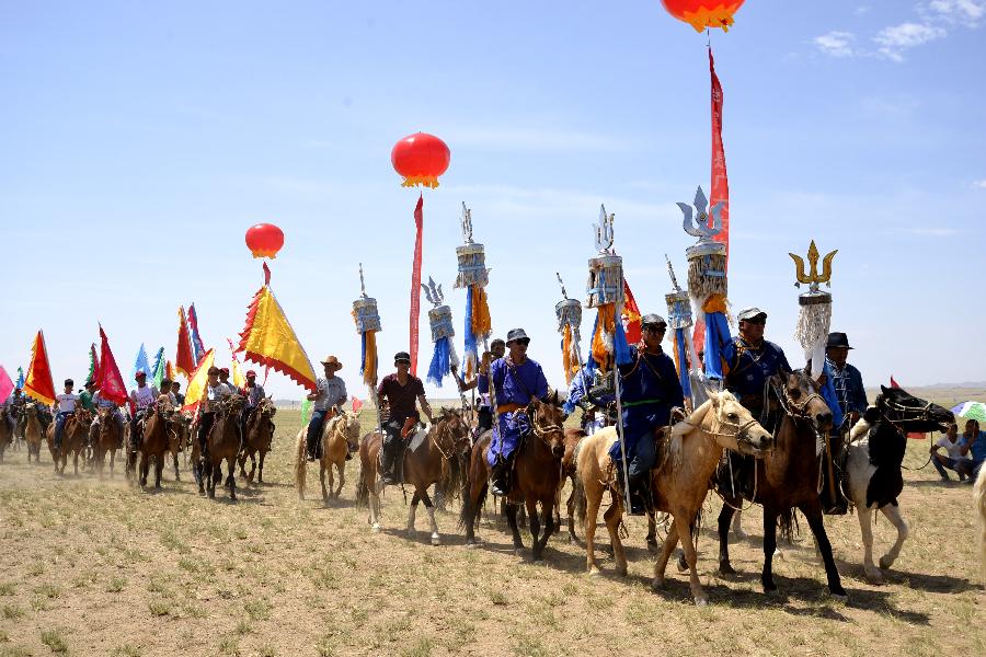 People attend a Nadam fair in Urat Middle Banner, north China's Inner Mongolia Autonomous Region, July 4, 2015. Nadam is a mass traditional Mongolian festival where people celebrate harvests and pray for good luck. [Xinhua]