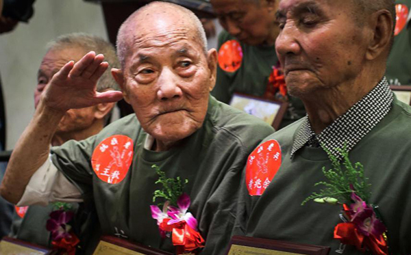 A veteran salutes at a meeting in Nanjing, Jiangsu province, July 5, 2015. A total of 33 veterans met to mark the 78th anniversary of the beginning of the War of Resistance against Japanese Aggression in July 7, 1937, in Nanjing, Jiangsu, July 5, 2015. [Photo/chinanews.com]