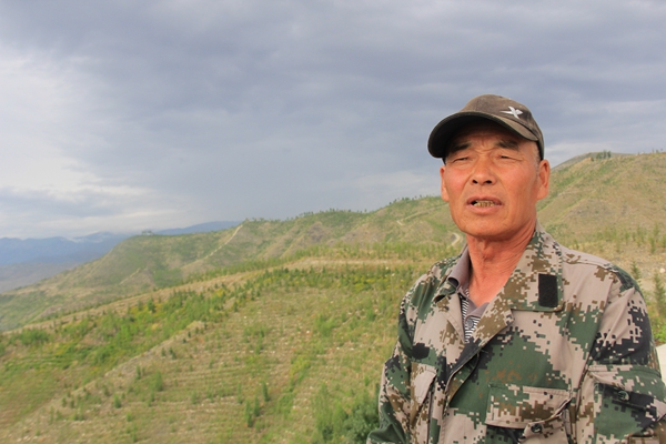 Xu Xiuqi, 63, is a retired forester who was reemployed to help plant trees in the barren mountains in Altay, Xinjiang Uygur autonomous region.[Photo by Xu Wei /China Daily]