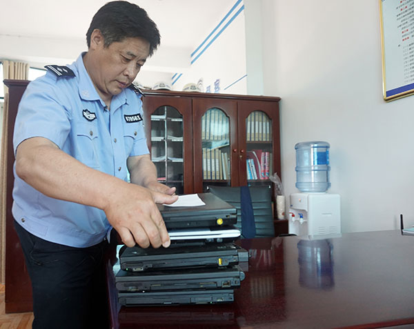 Police collect computers in May that had been seized during a crackdown on the gang that made millions of yuan by hacking into the Internet. Yu Guoqing / Xinhua