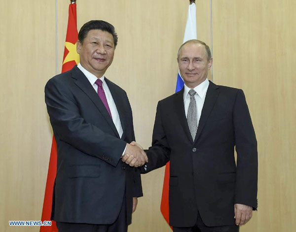 Chinese President Xi Jinping (L) shakes hands with his Russian counterpart Vladimir Putin in Ufa, Russia, July 8, 2015. [Xinhua]