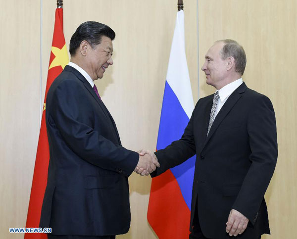 Chinese President Xi Jinping (L) shakes hands with his Russian counterpart Vladimir Putin in Ufa, Russia, July 8, 2015. [Xinhua]
