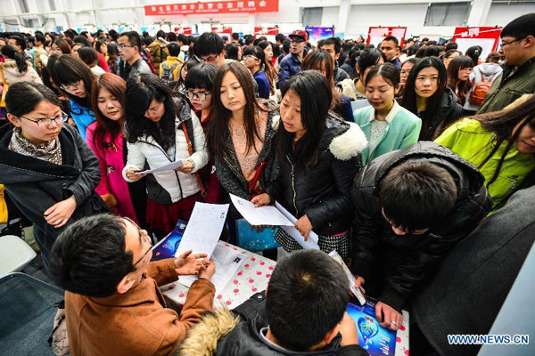 Job seekers consult recruiters about job information at a job fair held for fresh graduates in North China's Tianjin municipality, March 14, 2015. About 1,800 opportunities were offered at the fair. [You Sixing /Xinhua]