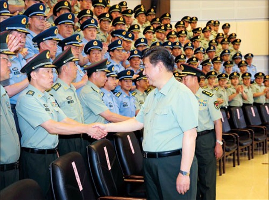 President Xi Jinping shakes hands with officers of the 16th army group on Saturday. Xi, who is also chairman of the Central Military Commission, called for training that would ensure that military personnel adapt to new situations and tasks and achieve the goal of a stronger army. — Xinhua