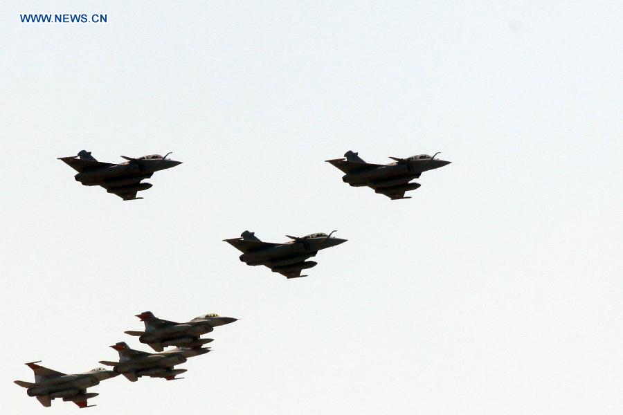 Three Rafale fighter jets from France (front) accompanied by warplanes of Egyptian Air Forces fly over downtown Cairo, Egypt, on July 21, 2015. The Egyptian Armed Forces received three Rafale fighter jets from France as the first batch of a deal signed between the two countries in February, the Egyptian military spokesman said on Monday. [Photo/Xinhua] 