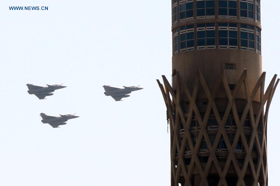 Three Rafale fighter jets from France fly over the landmark Cairo Tower in downtown Cairo, capital of Egypt, on July 21, 2015. The Egyptian Armed Forces received three Rafale fighter jets from France as the first batch of a deal signed between the two countries in February, the Egyptian military spokesman said on Monday. [Photo/Xinhua]