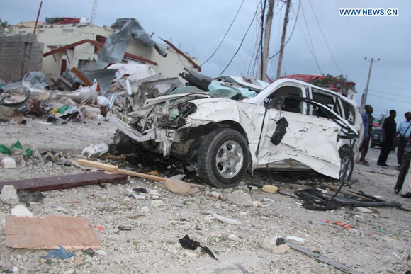 Photo taken on July 26, 2015 shows the wreckage of a car at the suicide attack scene of Jazera Hotel in Mogadishu, Somalia. At least 15 people were killed and several others injured Sunday in a hotel blast in the Somali capital Mogadishu, police said. [Photo/Xinhua]