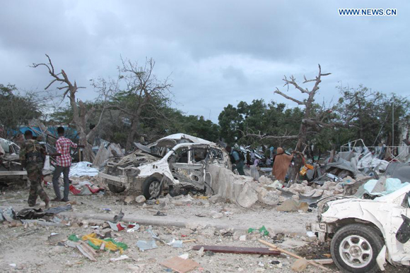 Photo taken on July 26, 2015 shows the wreckage of a car at the suicide attack scene of Jazera Hotel in Mogadishu, Somalia. At least 15 people were killed and several others injured Sunday in a hotel blast in the Somali capital Mogadishu, police said. [Photo/Xinhua]
